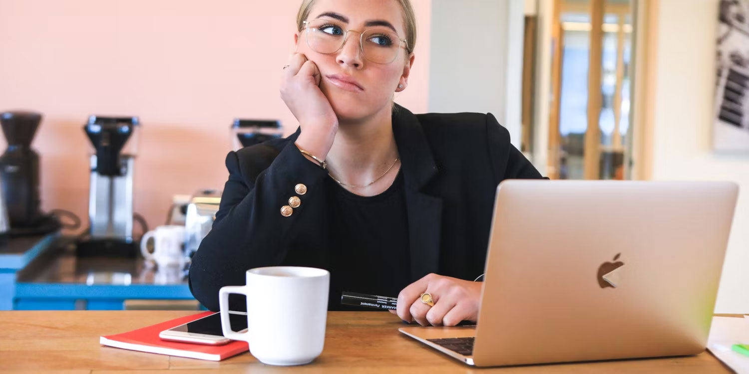 Người phụ nữ ngồi tư duy trước laptop