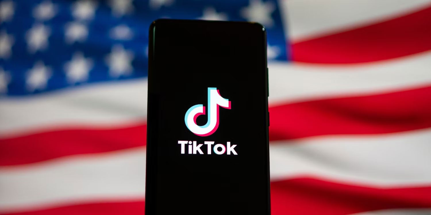 Logo TikTok trên điện thoại thông minh có cờ Mỹ ở phía sau