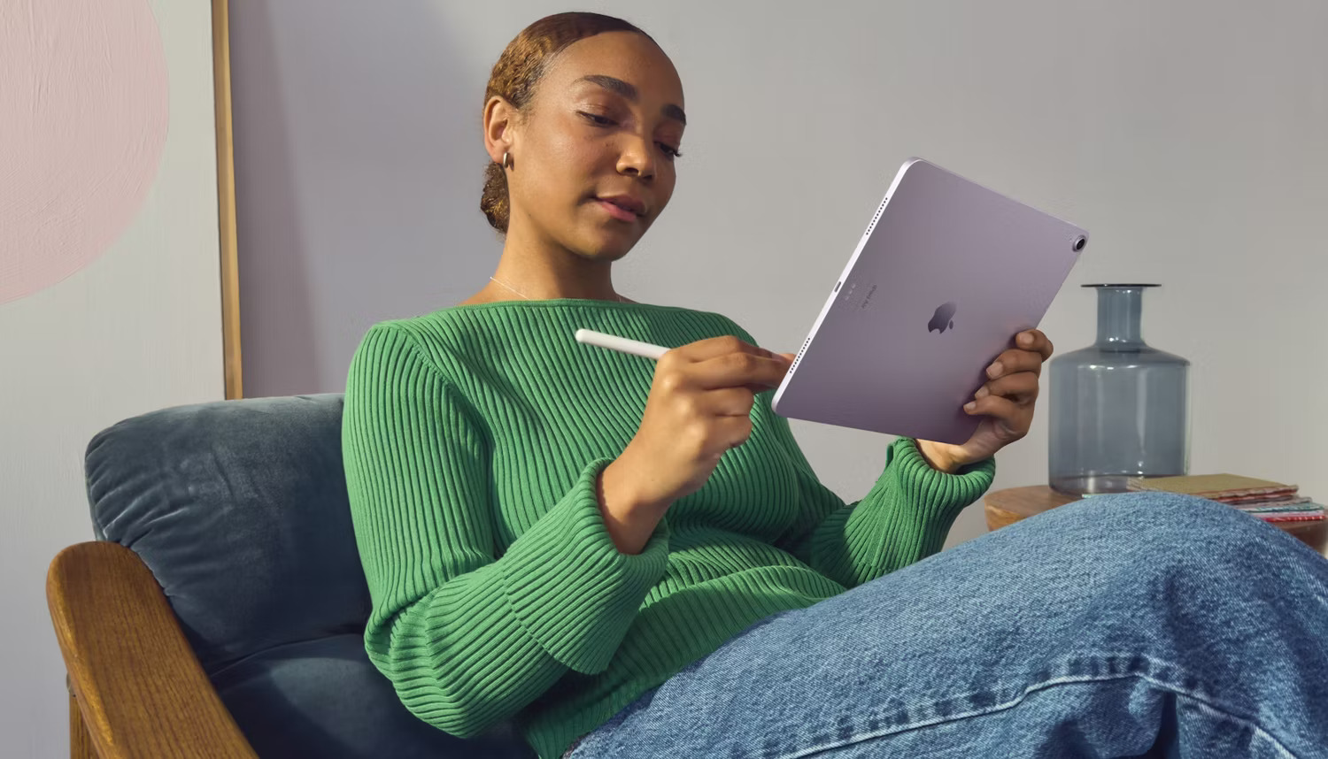 Người phụ nữ cầm iPad Air bằng một tay trong khi sử dụng Apple Pencil