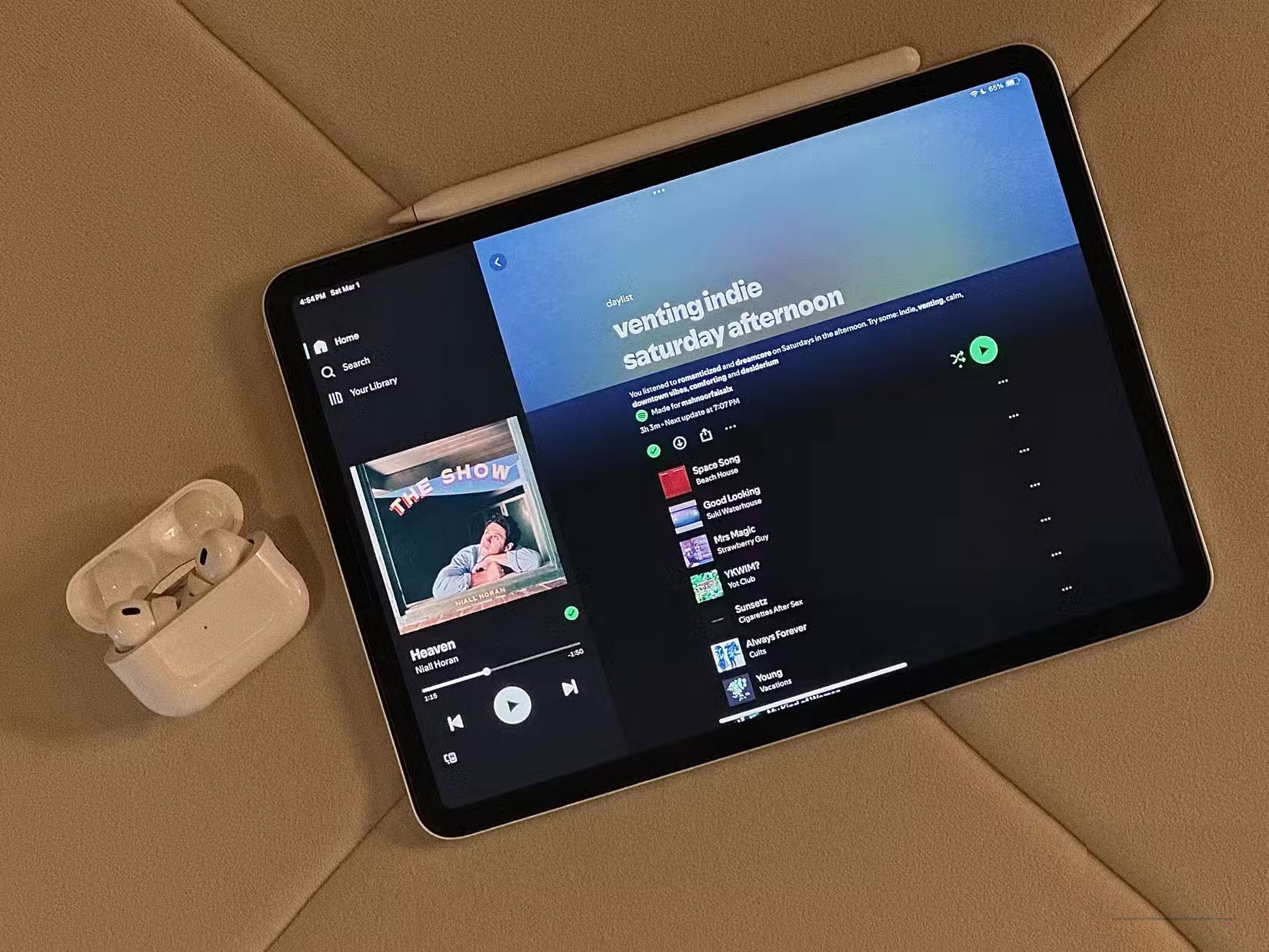 Daylist trên iPad bên cạnh hộp đựng Airpods