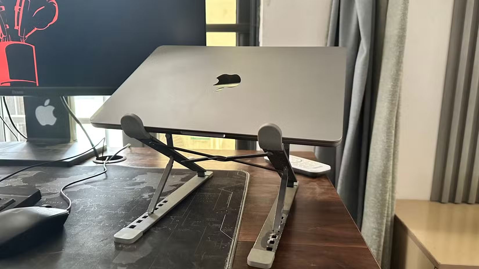 MacBook trên giá đỡ máy tính xách tay cạnh màn hình