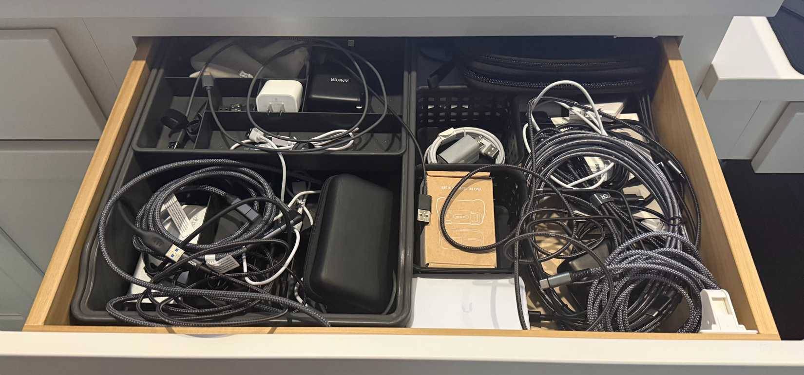 Nhiều dây cáp sạc trong ngăn kéo bàn