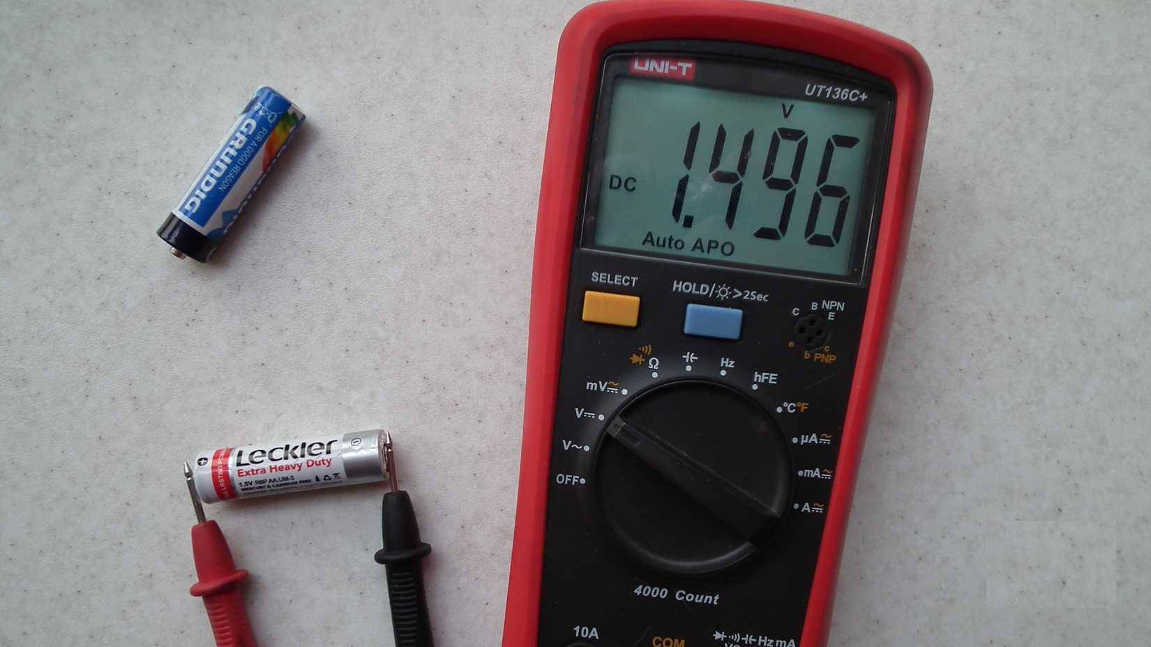 Một đồng hồ vạn năng đang đo điện áp của pin AA