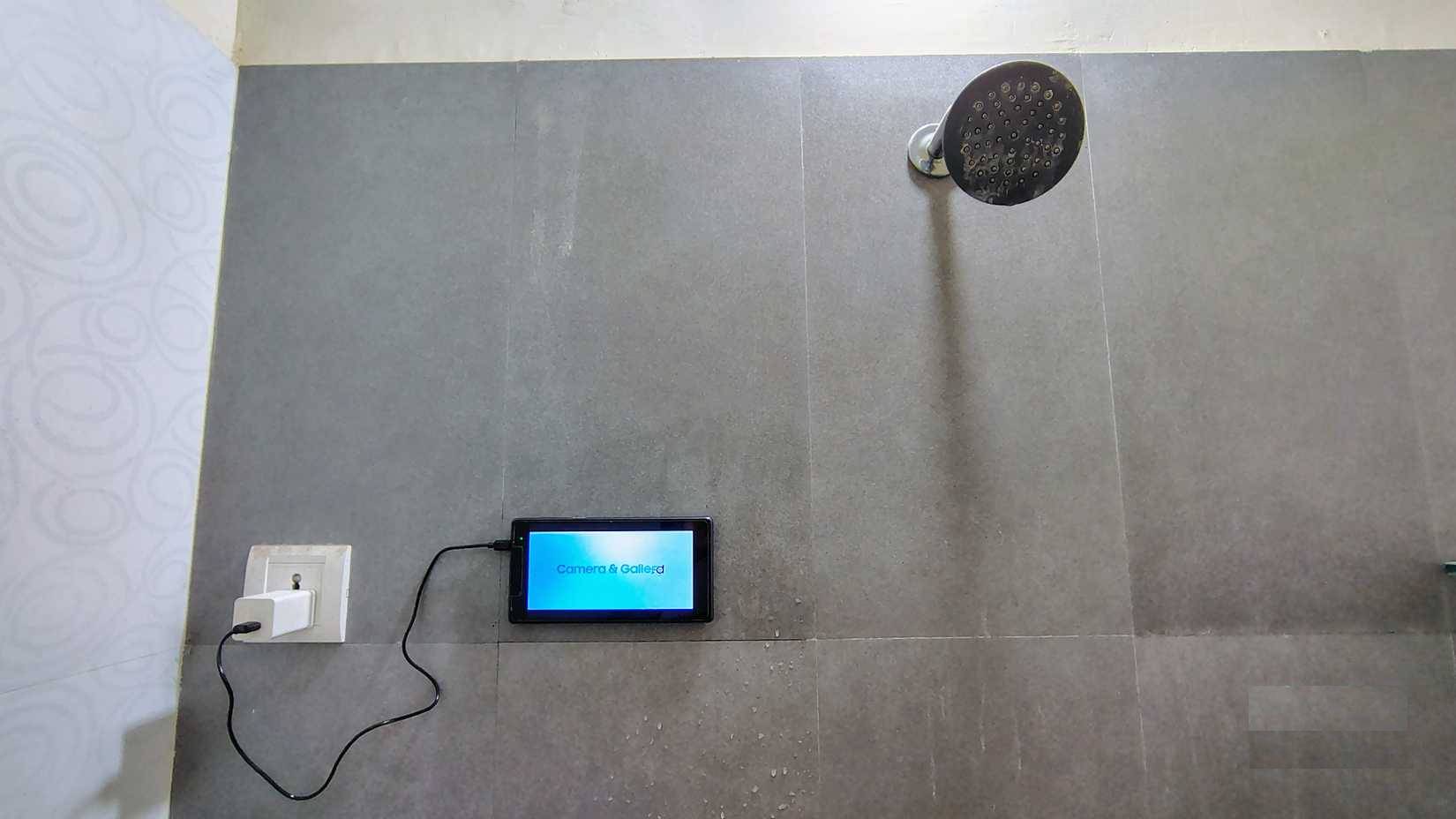 Máy tính bảng cũ được gắn trên tường phòng tắm bằng miếng dán