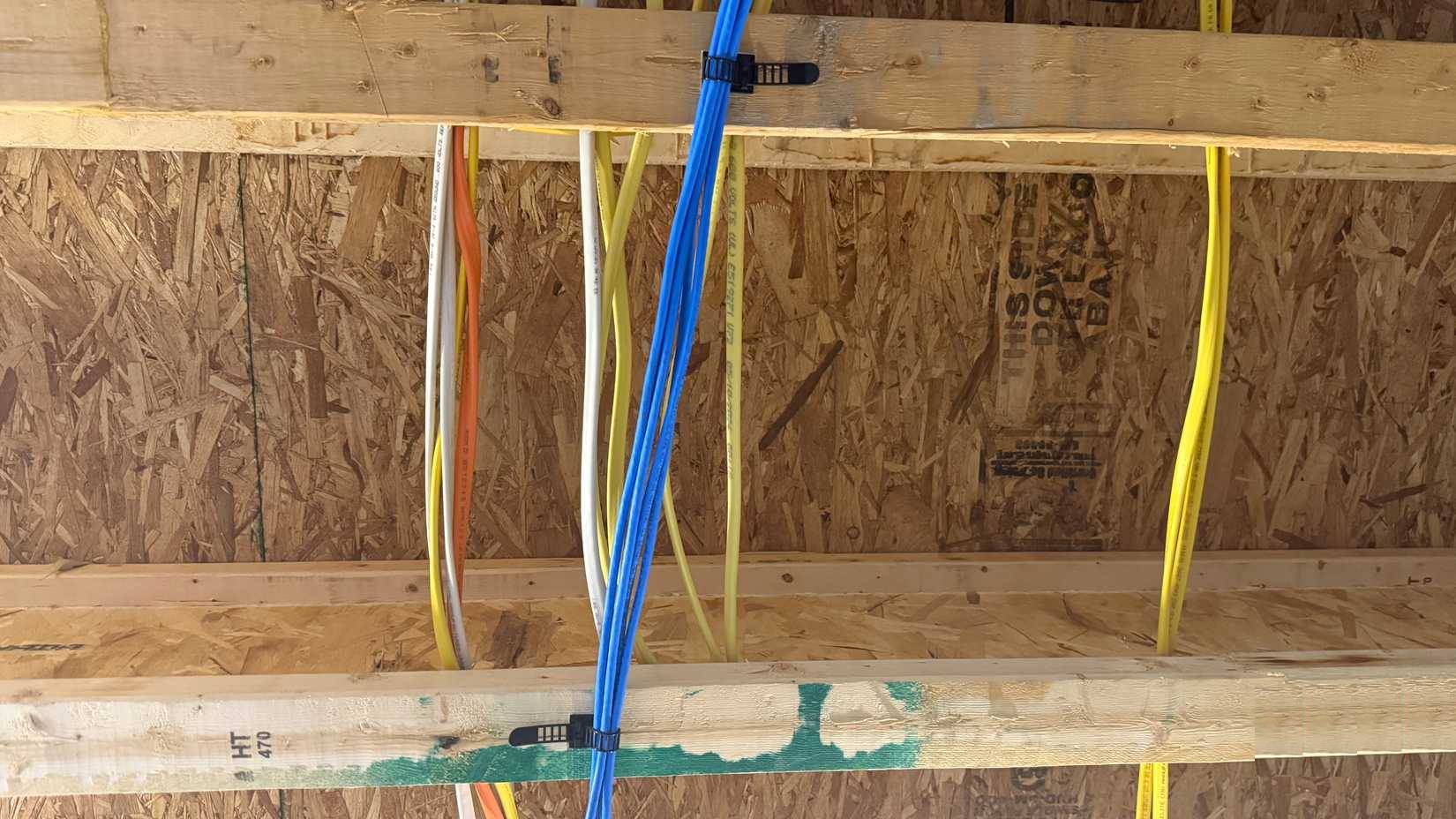 Nhiều cáp Cat6 được cố định vào mặt dưới của dầm sàn trên trần tầng hầm