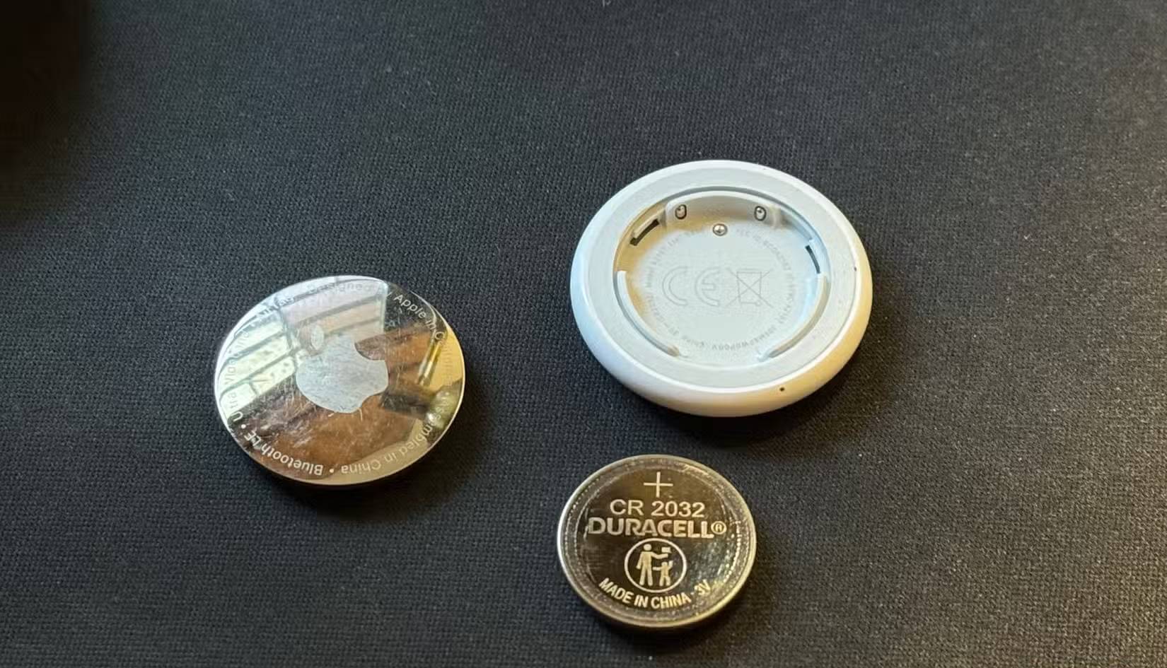 Một chiếc AirTag đã được tháo rời cùng với pin CR 2032 của nó