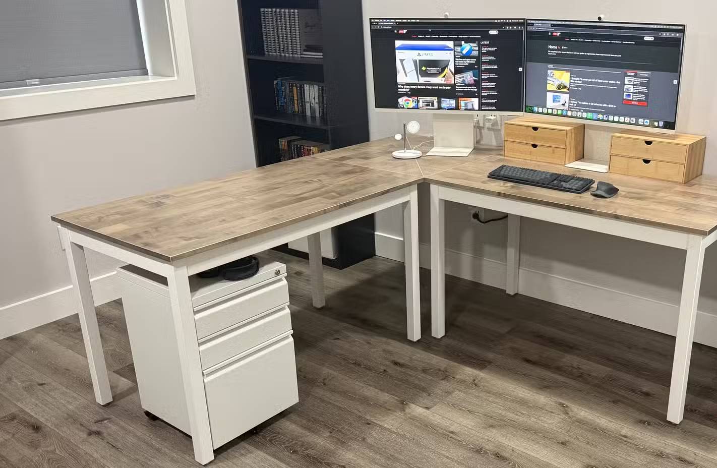 Bàn làm việc hình chữ L với hai màn hình và dây cáp được giấu bên dưới